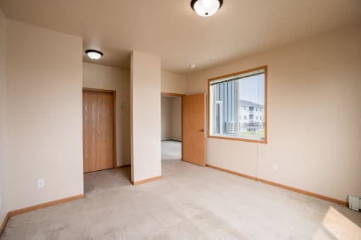 a bedroom with a large window. West Fargo, ND West Lake Apartments 11A