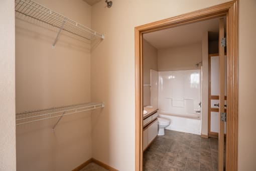 a bathroom with a closet and a toilet and a bath tub. West Fargo, ND West Lake Apartments 11A