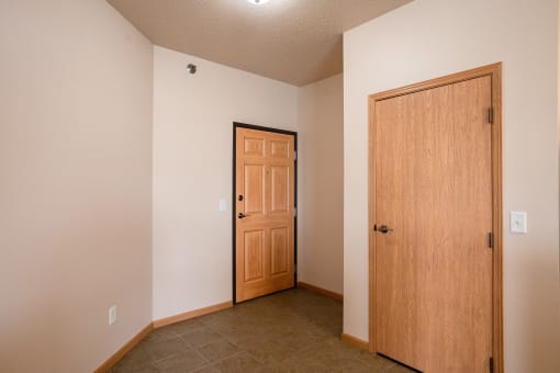 an empty room with a door and a closet. West Fargo, ND West Lake Apartments 11A