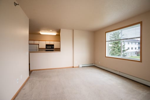 the living room of an empty apartment with a large window. West Fargo, ND West Lake Apartments