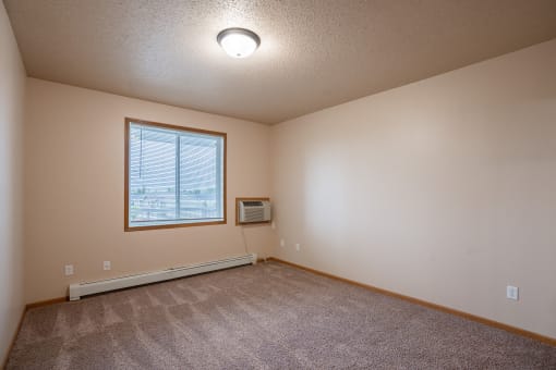 a bedroom with a window. Fargo, ND West Lake Apartments