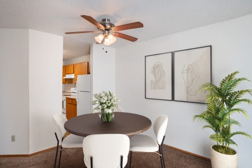 a dining room with a table and chairs and a ceiling fan. Fargo, ND Westview Towers Apartments