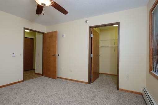 a bedroom with a walk in closet. Fargo, ND Crossroads Apartments
