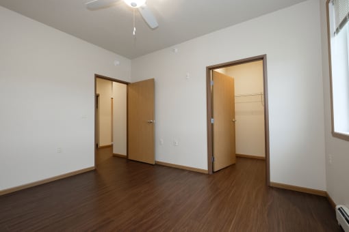 a bedroom with wood floors and a closet. Fargo, ND North Sky Apartments