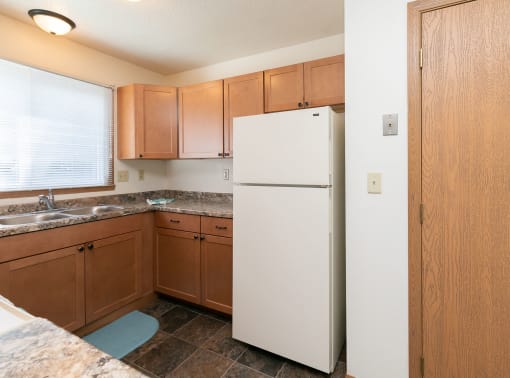 a kitchen with a stove refrigerator and sink. Fargo, ND White Ridge Apartments