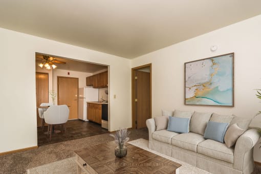 Apartment a living room with a couch and coffee table with a dining room in the background  at Amberwood Court, Grand Forks, ND, 58201