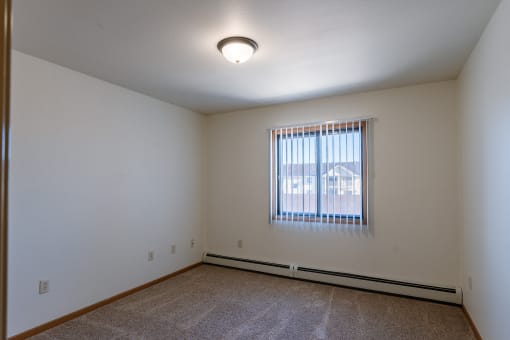 a bedroom with a window. Grand Forks, ND Autumn Ridge Apartments