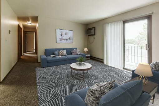 Grand Forks, ND Carling Manor Apartments.  a living room with two couches and a coffee table in front of a sliding glass door