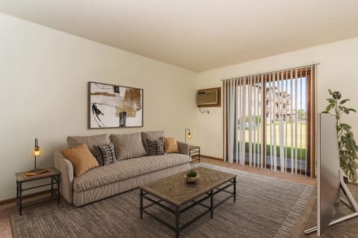 a living room with a couch and a coffee table. Grand Forks, ND Chandler 1898 Apartments