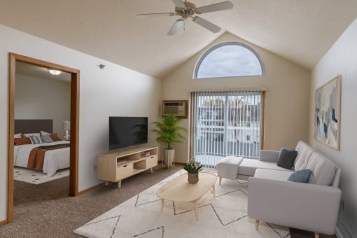 a living room with a couch and a tv and a bedroom. Grand Forks, ND Creekside Apartments.
