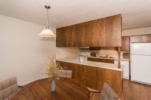 Grand Forks Kremer Apartments. A dining room with a four-chair table and a kitchen in the background