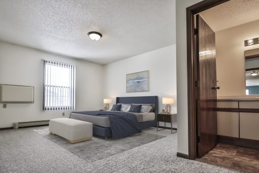 Grand Forks Primrose Apartments. A bedroom with a bed and a chair in a room
