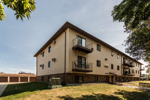 Grand Forks Ridgemont Apartments. An exterior of a three level apartment building with garages in the background.