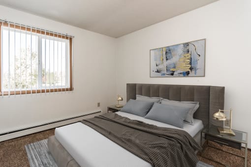 Grand Forks, ND Riverwood Apartments. A bedroom with a bed and a large window
