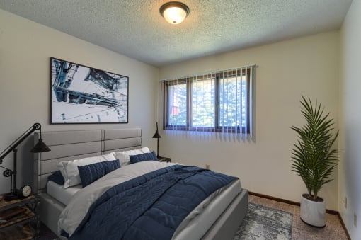 Grand Forks, ND Roughrider Apartments.  a bedroom with a large bed and two windows
