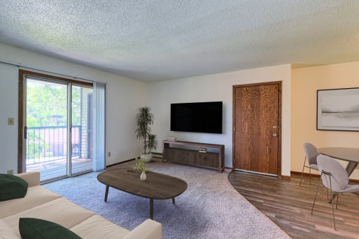 Grand Forks, ND Roughrider Apartments. a living room with a couch a table and a tv