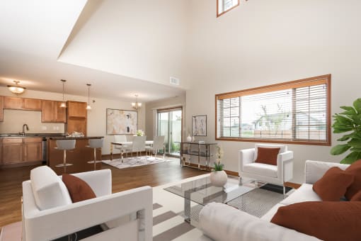 a living room with white couches and chairs and a glass coffee table  at Sterling Pointe, North Dakota