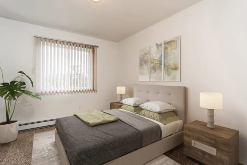 Grand Forks, ND Vista Apartments. A bedroom with a bed, night stand, and a plant in the corner next to the window.