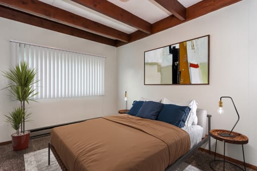 Grand Forks, ND Washington Apartments. a bedroom with a bed and a large painting on the wall