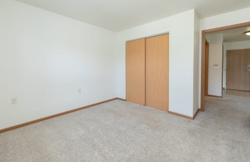 a bedroom with a closet and carpeted floors. Fargo, ND Sunrise North