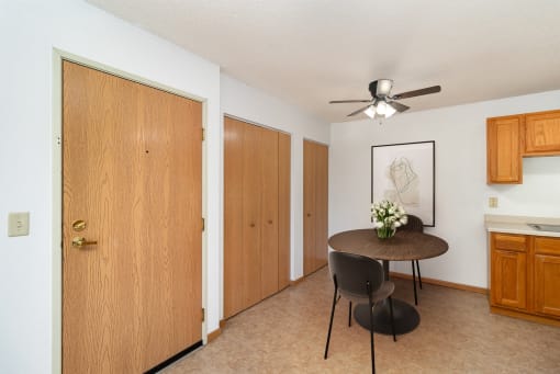 a dining room with a table and a ceiling fan. Hutchinson, MN Deer Park Apartments