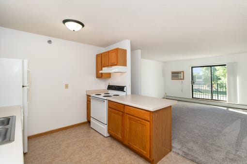 an empty kitchen with a stove and a refrigerator. Hutchinson, MN Deer Park Apartments