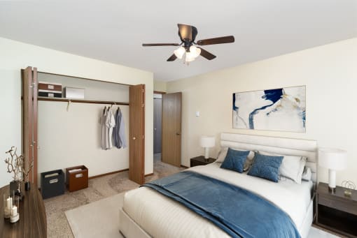 a bedroom with a large bed and a ceiling fan. Hutchinson, MN Twin Oaks