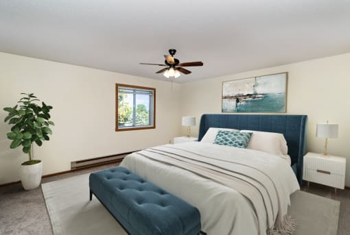 a bedroom with a large bed and a ceiling fan. Hutchinson, MN Twin Oaks