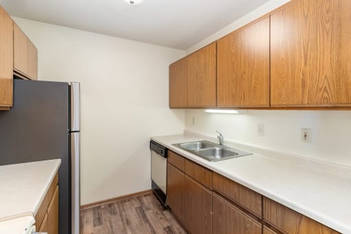 an apartment kitchen with sink and refrigerator. Hutchinson, MN Twin Oaks