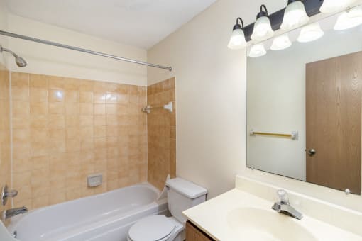 a bathroom with a tub and a sink and a toilet. Hutchinson, MN Twin Oaks Townhomes