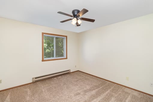 a bedroom of an empty house with a ceiling fan. Hutchinson, MN Twin Oaks
