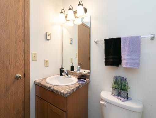 a bathroom with a sink and toilet. Fargo, ND White Ridge Apartments