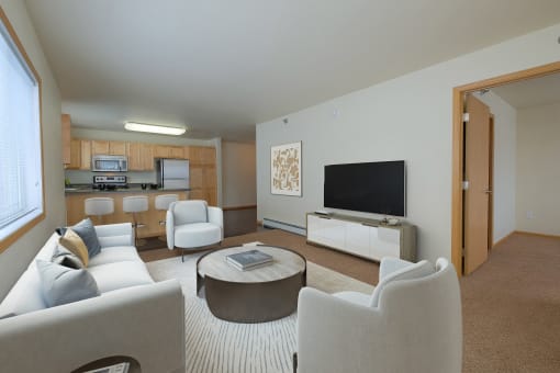 a living room with couches and chairs and a television. Moorhead, MN Sandy Creek Apartments