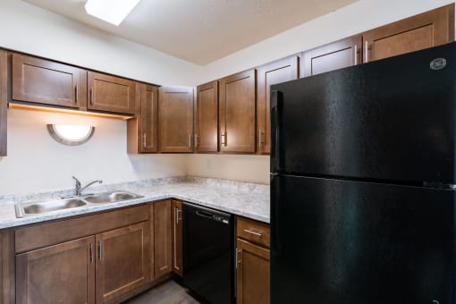 full kitchen with black refrigerator and sink at the reserve at walnut creek apartments. Moorhead, MN South Park Apartments