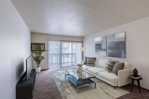 a living room with a couch and a coffee table. Moorhead, MN South Park Apartments