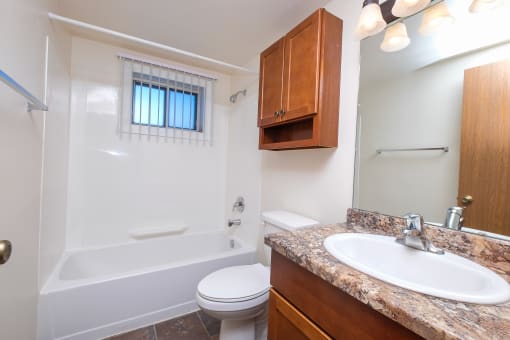 a bathroom with a sink toilet and a bath tub. Fargo, ND North Manor Apartments