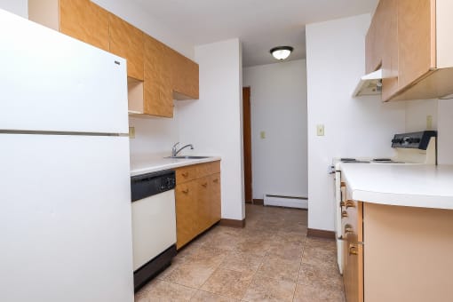 an empty kitchen with a refrigerator and a sink. Fargo, ND North Manor Apartments