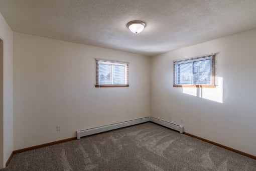 a bedroom with two windows. Fargo, ND North Manor Apartments