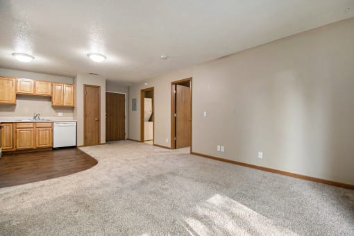 Omaha, NE Deerfield Apartments. A spacious living room with a kitchen in the background