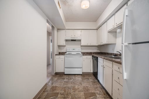 Omaha, NE Evergreen Terrace Apartments. A kitchen with white cabinets and white appliances