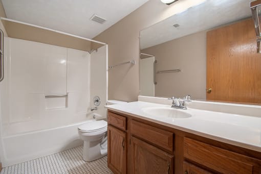 Omaha, NE Woodland Pines Apartments. A bathroom with a toilet sink and bathtub