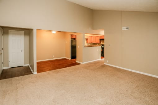 an empty living room and kitchen with wood flooring. Omaha, NE Evergreen Terrace Apartments