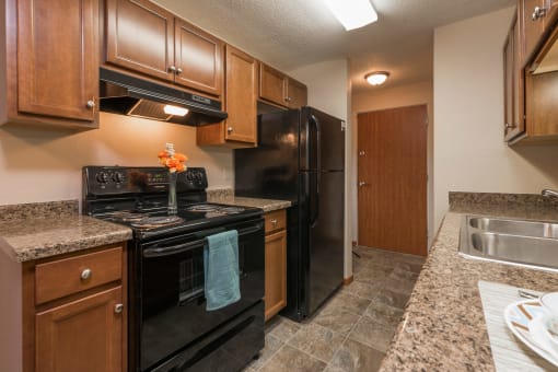 Kitchen with Black Appliances at Parkview Arms Apartments in Bismarck, ND