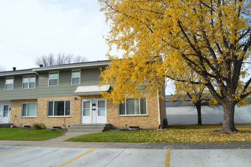 the front of a house with a tree with yellow leaves. Fargo, ND Sheyenne Terrace