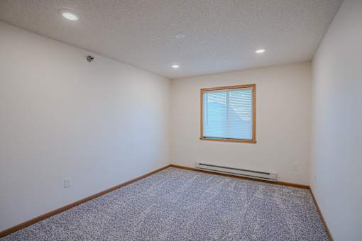 a bedroom with a window. Fargo, ND Lake Crest Apartments