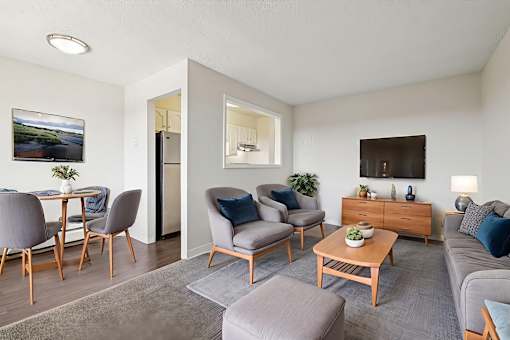 A living room with a grey couch, a wooden coffee table, and a painting on the wall.
