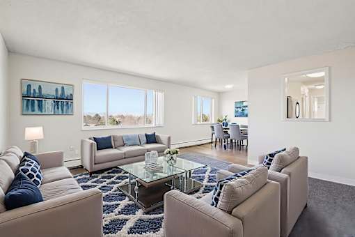 A living room with a glass coffee table and two couches.