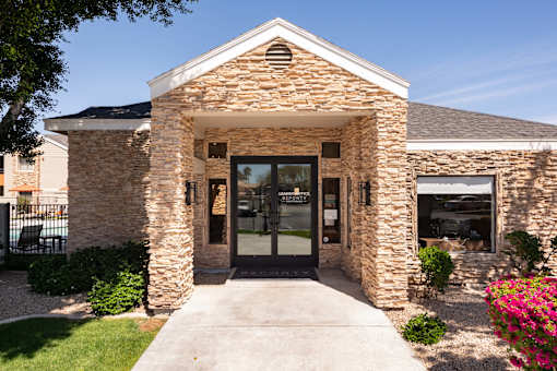 the front entrance of a brick building with glass doors