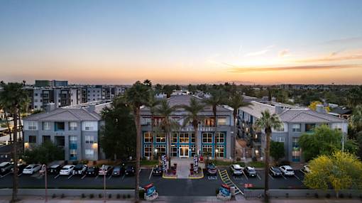 A hotel with a parking lot in front of it.