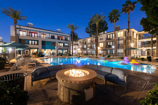 A poolside area with a fire pit in the middle of the pool.